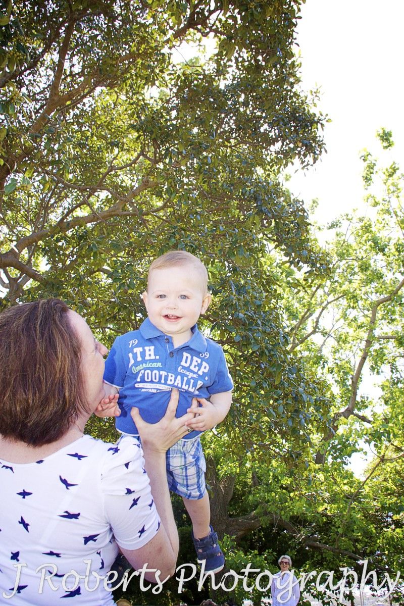Mum throwing little boy up in the air - family portrait photography sydney